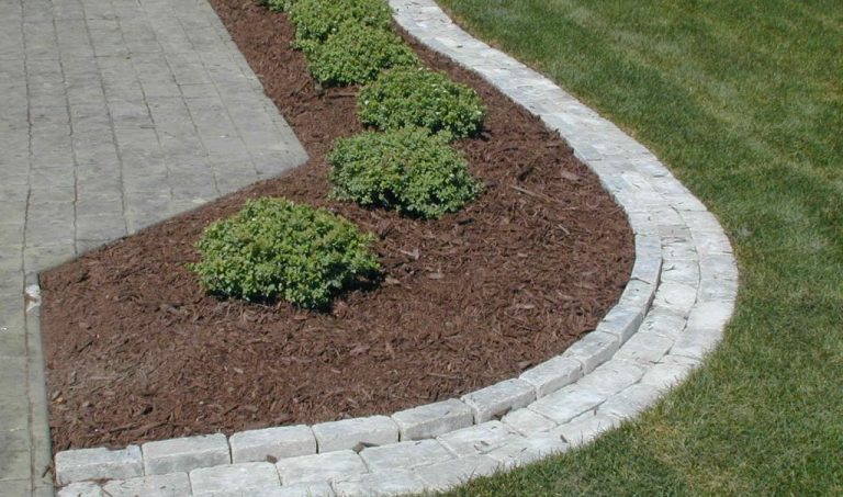 Paver edger for transitioning between lawn and mulch landscapes.